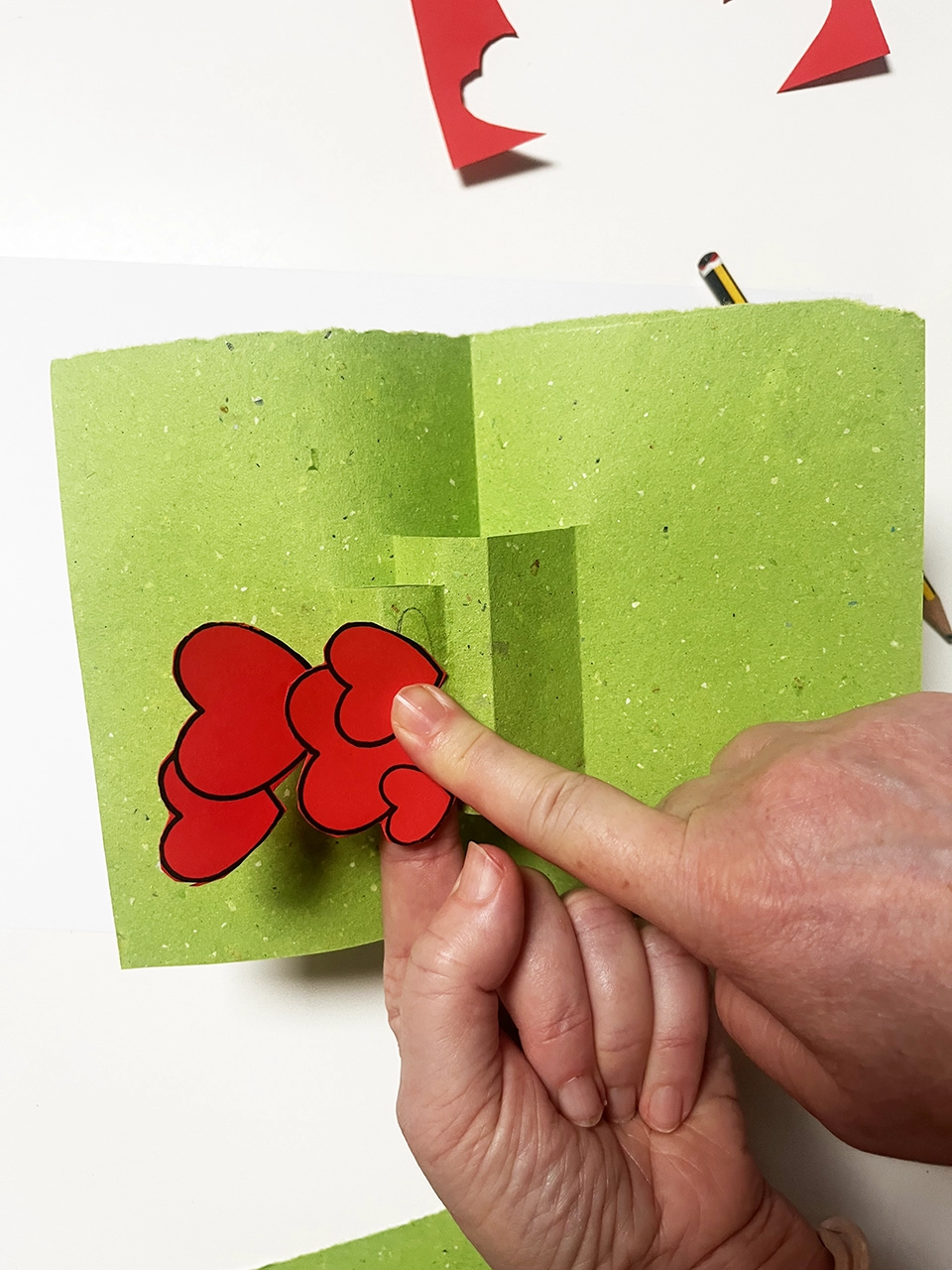pop up tutorial - Incolla i cuori. Attenzione: i cuori non devono sporgere oltre il bordo.